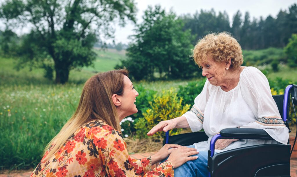 Young woman taking care of older woman on wheelchair